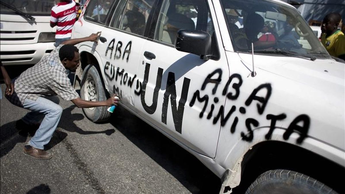 Un manifestante pinta sobre un auto de las Naciones Unidas, en Puerto Príncipe (Haití), durante una protesta convocada por 12 candidatos presidenciales haitianos que rechazan los resultados de los comicios celebrados el 28 de noviembre pasado. EFE