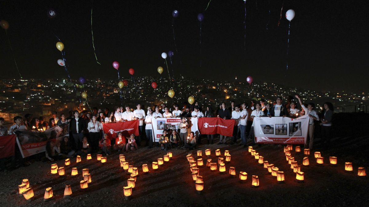 Varios niños ponen con velas el nombre de Siria en el segundo aniversario del comienzo de la guerra