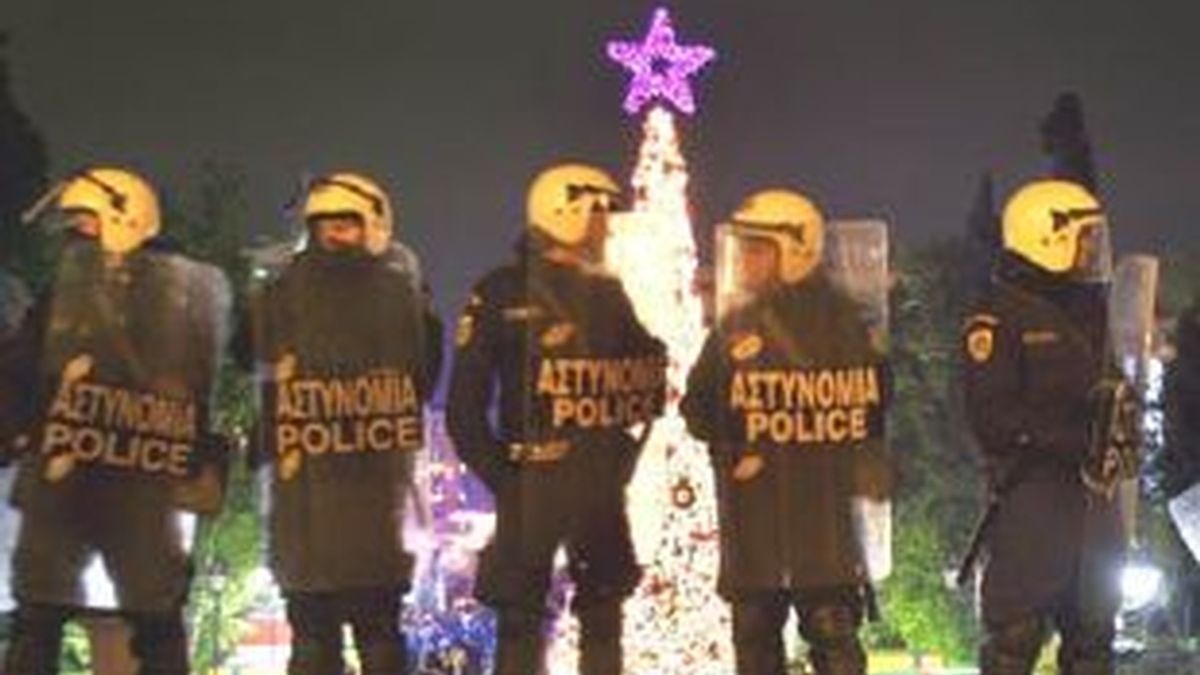 Oficiales de policía resguardan la calle junto a un árbol de Navidad en la plaza principal de Atenas. Foto: EFE