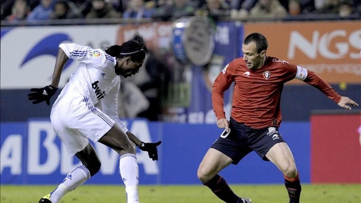 El delantero togolés del Real Madrid Emmanuel Adebayor (i) encara con el balón al centrocampista del Osasuna Patxi Puñal durante el partido correspondiente a la vigésimo primera jornada del Campeonato Nacional de Liga de Primera División. EFE