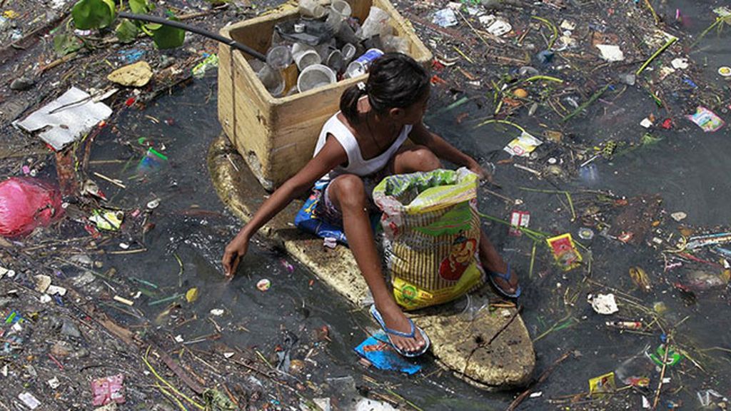 Niños filipinos nadando entre basura para sobrevivir