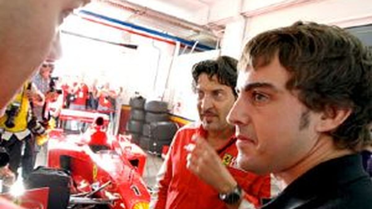 Fernando Alonso atiende a las explicaciones de un técnico de la escudería Ferrari sobre uno de los monoplazas. Foto: EFE