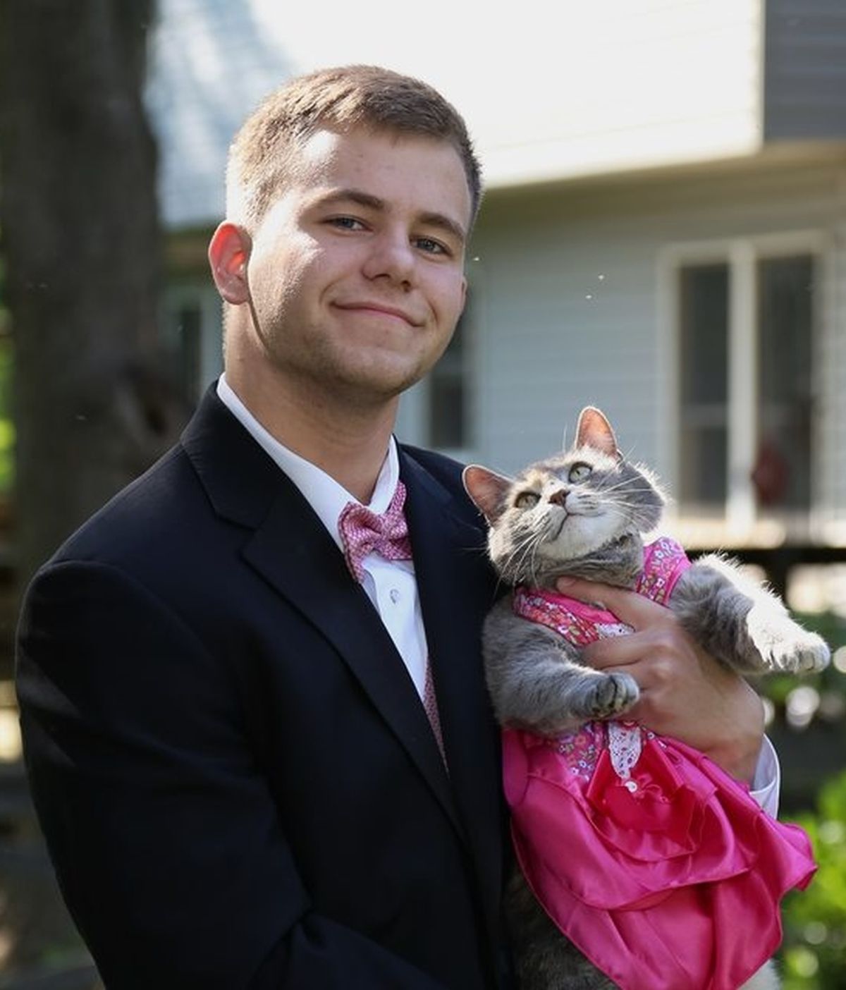 Un joven va con su gato a la graduación
