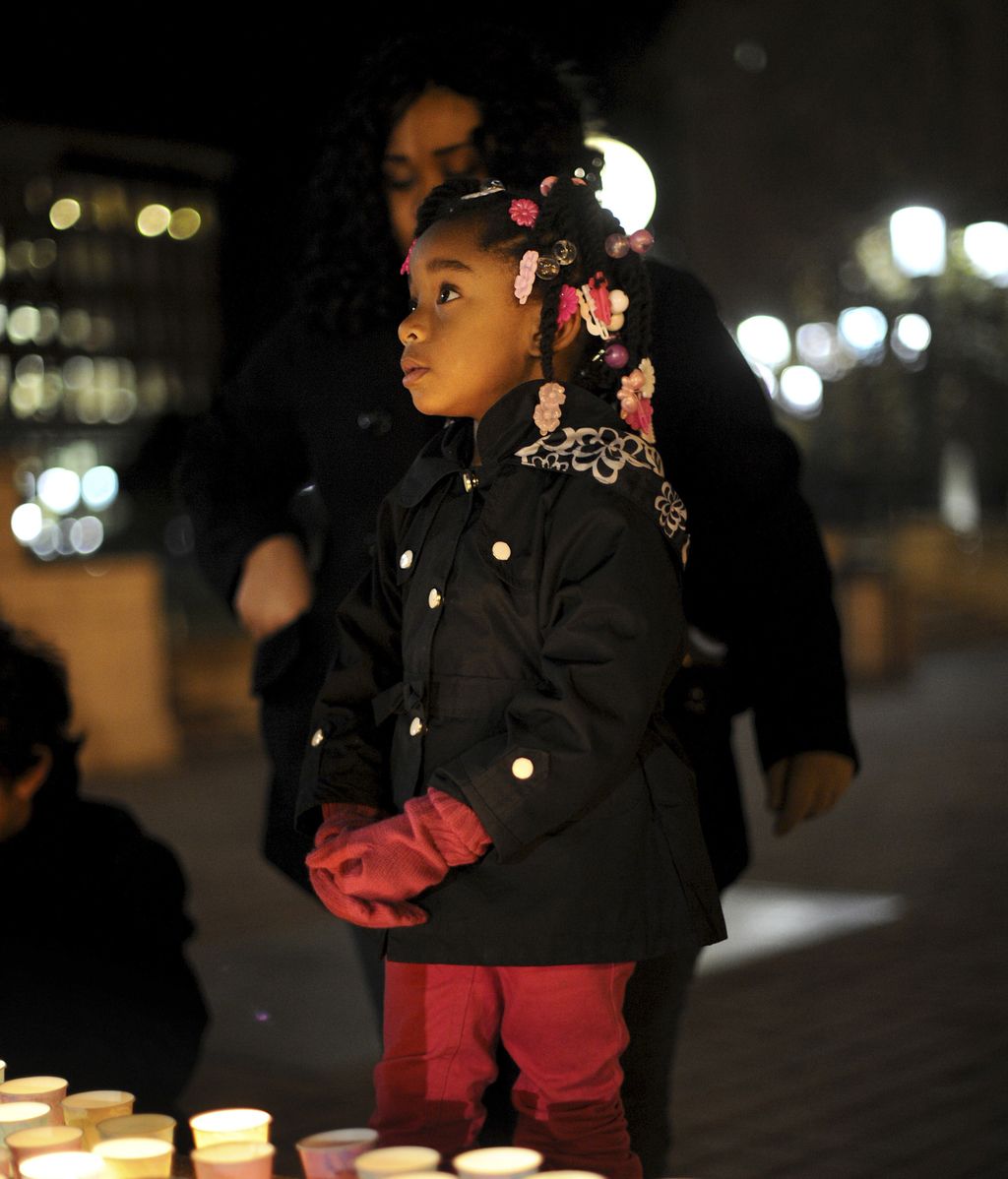 Una niña iluminada por las velas en la vigilia en honor a las víctimas de Connecticut