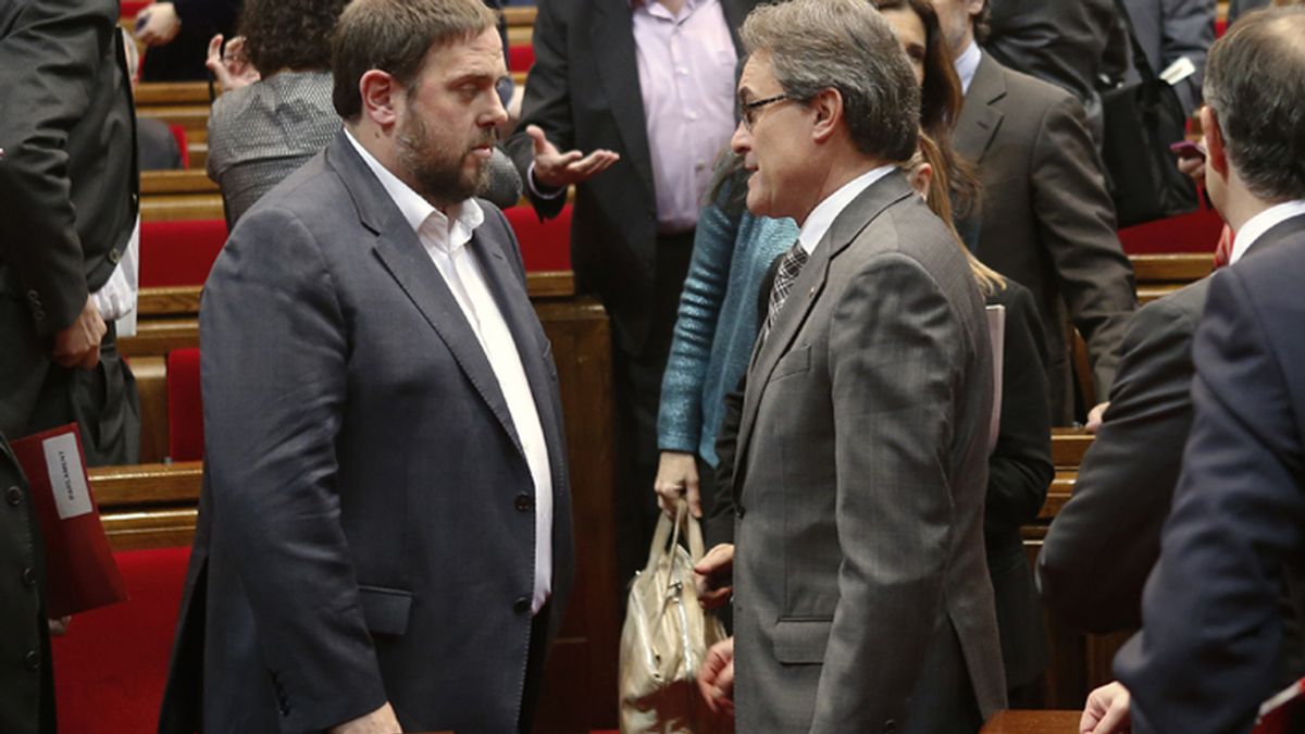 Oriol Junqueras y Artur Mas se saludan durante una sesión del Parlamento de Cataluña