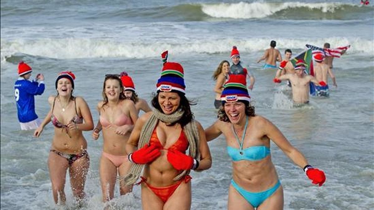Holandeses con gorros rojos participan en el tradicional baño en el Mar del Norte, durante la celebración del Año Nuevo, en la playa Scheveningen de La Haya, Holanda, hoy. EFE