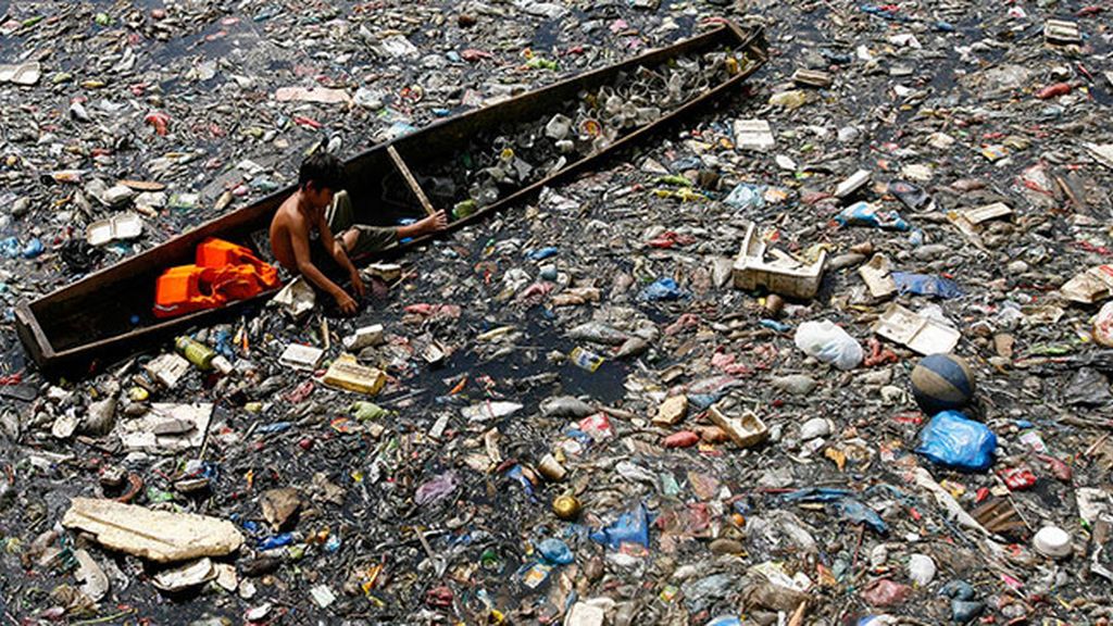 Niños filipinos nadando entre basura para sobrevivir