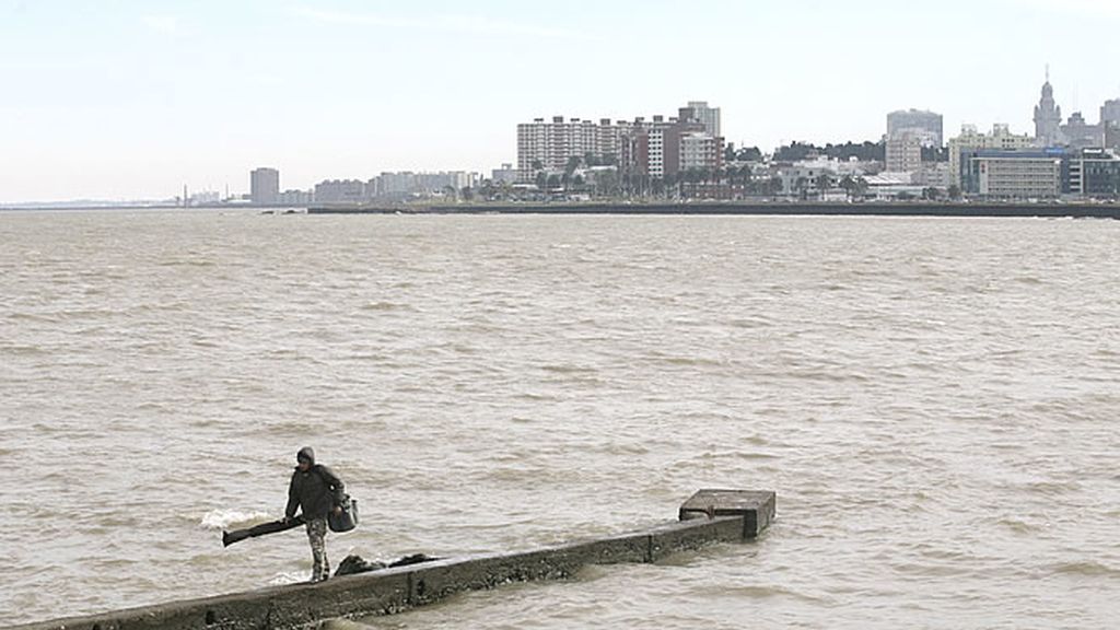 Un pescador camina junto al espectacular paisaje de la capital uruguaya, Montevideo