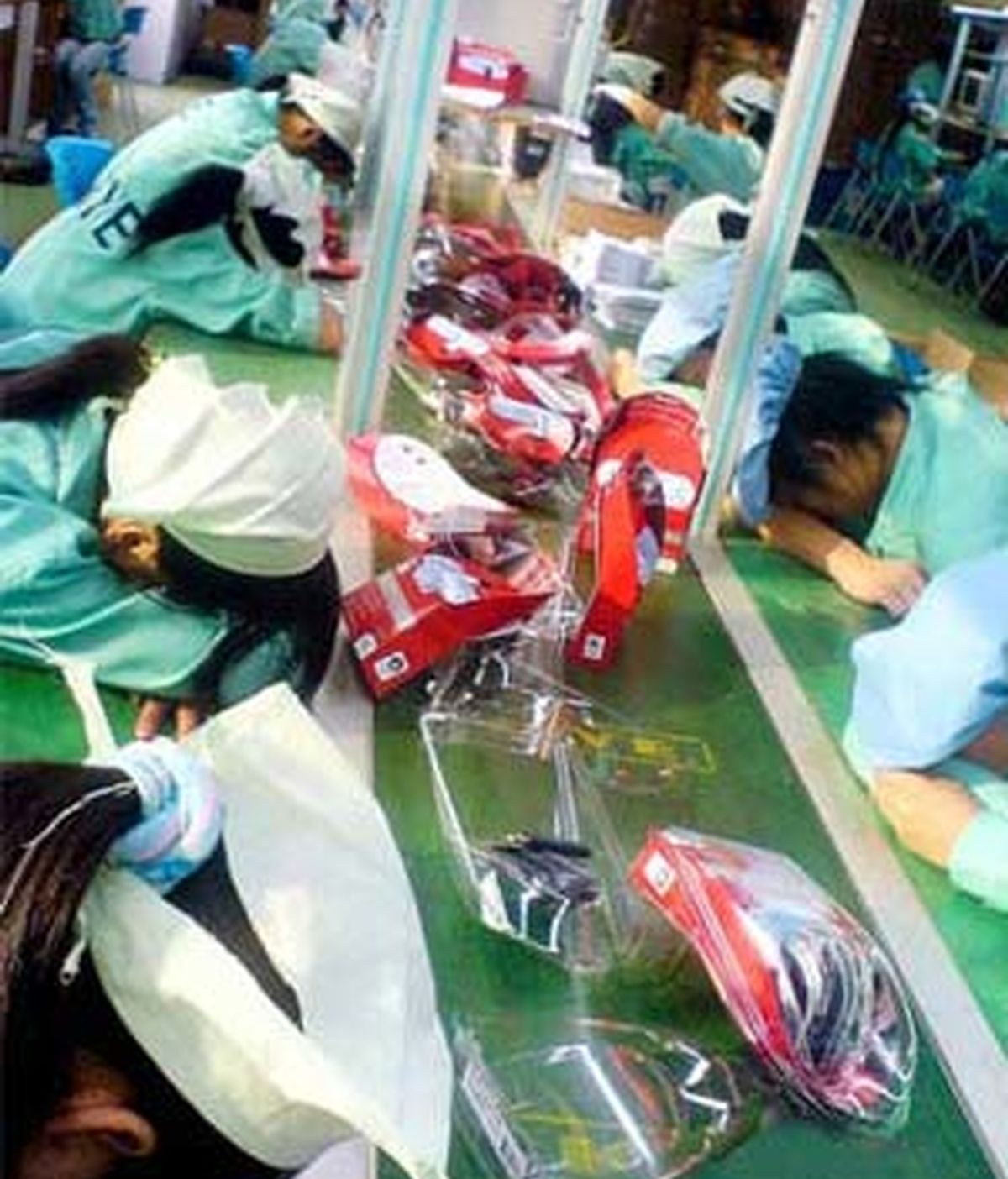 Imagen conseguida por la NLC de trabajadores chinos dormidos sobre sus mesas de trabajo. Foto: The Daily Mail