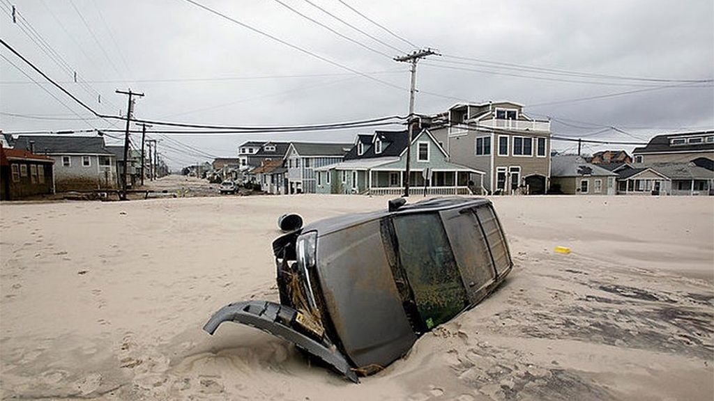 Un coche aparece en medio de una playa de Nueva ersey tras el paso de Sandy