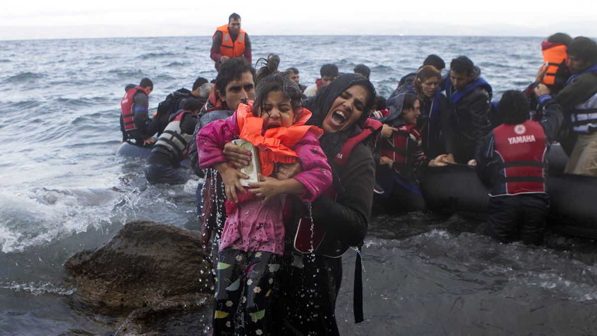 Una refugiada siria saca a una niña del mar