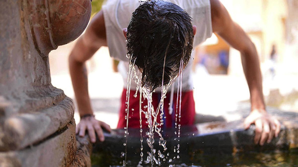 Un niño se refresca en una fuente para evitar sufrir un golpe de calor