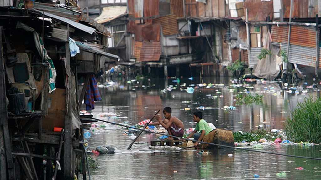 Niños filipinos nadando entre basura para sobrevivir