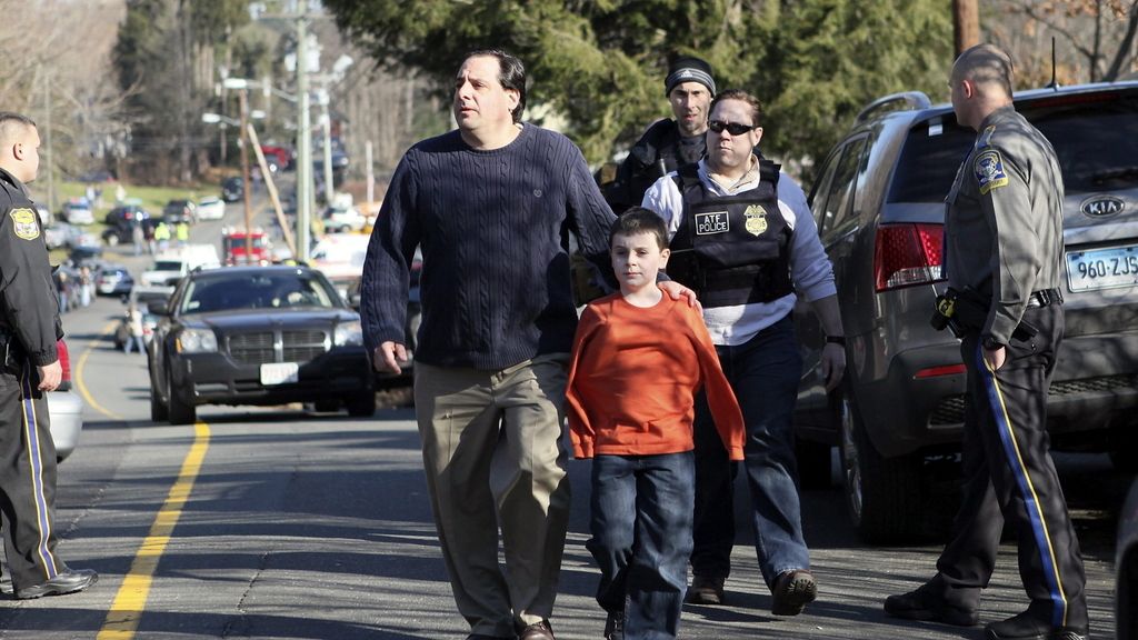 Un niño y su padre salen de la escuela primaria Sandy Hook tras la tragedia