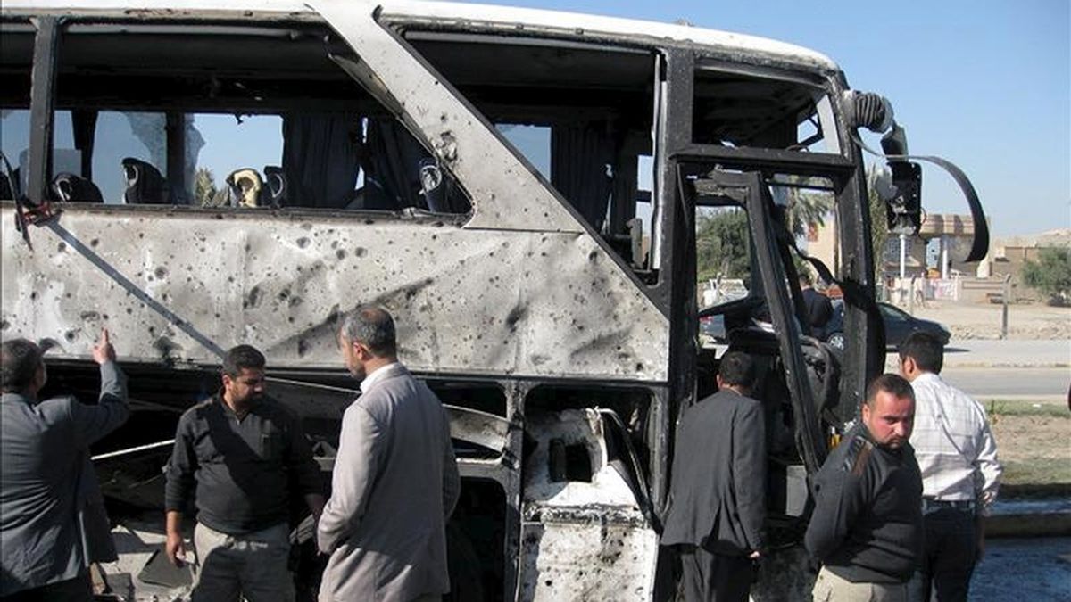 Iraquíes inspeccionan los restos de un autobús objeto de un atentado en Bagdad. EFE/Archivo