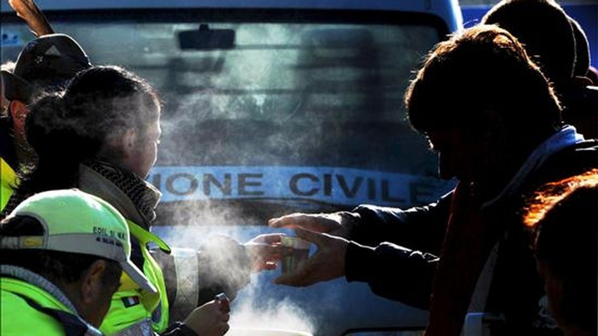 Un voluntario distribuye bebidas calientes entre los damnificados del terremoto en la localidad de Paganica (Italia) hoy miércoles 8 de abril. EFE