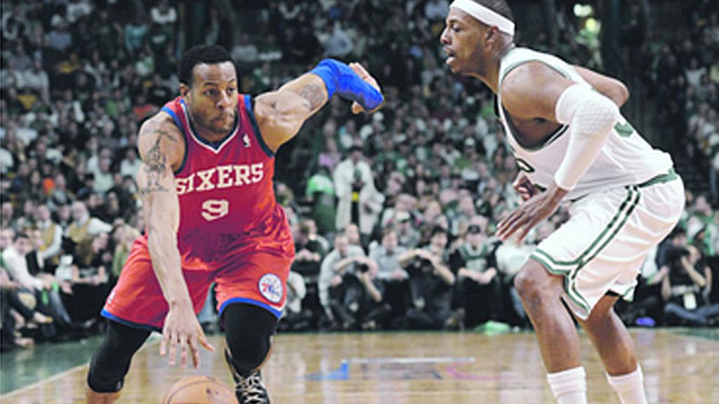 El líder de los Sixers de Philadelphia, Iguodala (9) intenta meterse ante la marca de Pierce, de los Celtics