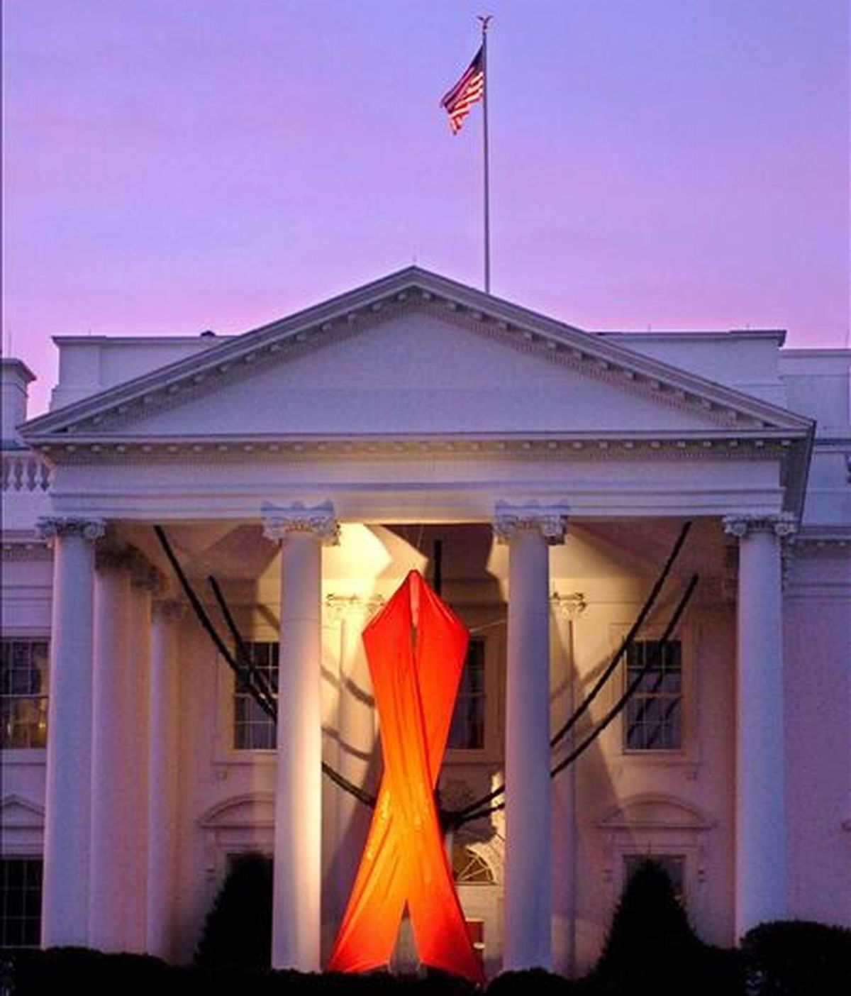 Un lazo rojo gigante cuelga en el Pórtico Norte de la Casa Blanca en conmemoración del Día Mundial del SIDA, que se celebra el 1 de diciembre. EFE/Archivo