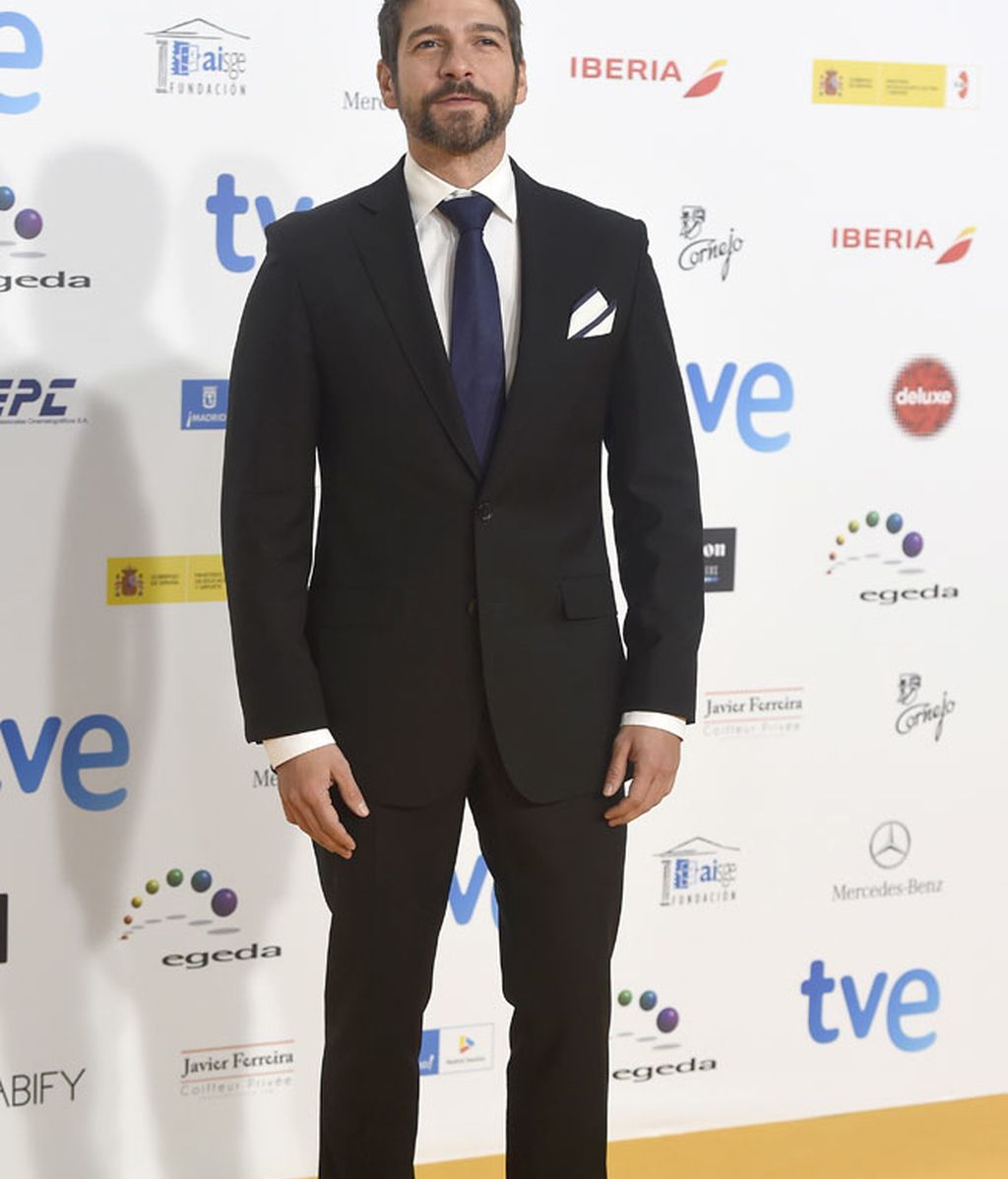 Félix Gómez con traje negro y corbata azul