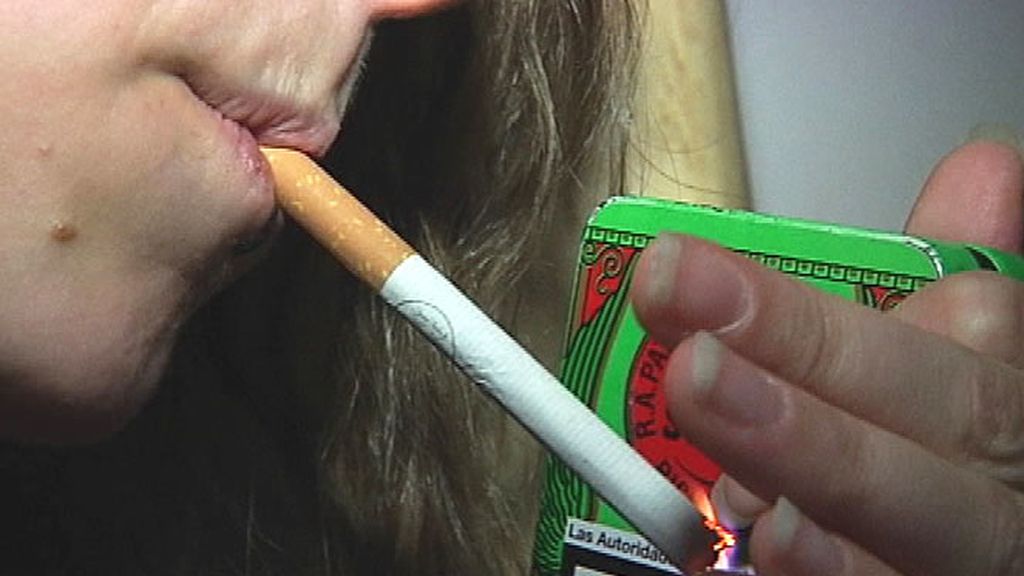 Una chica se enciende un pitillo