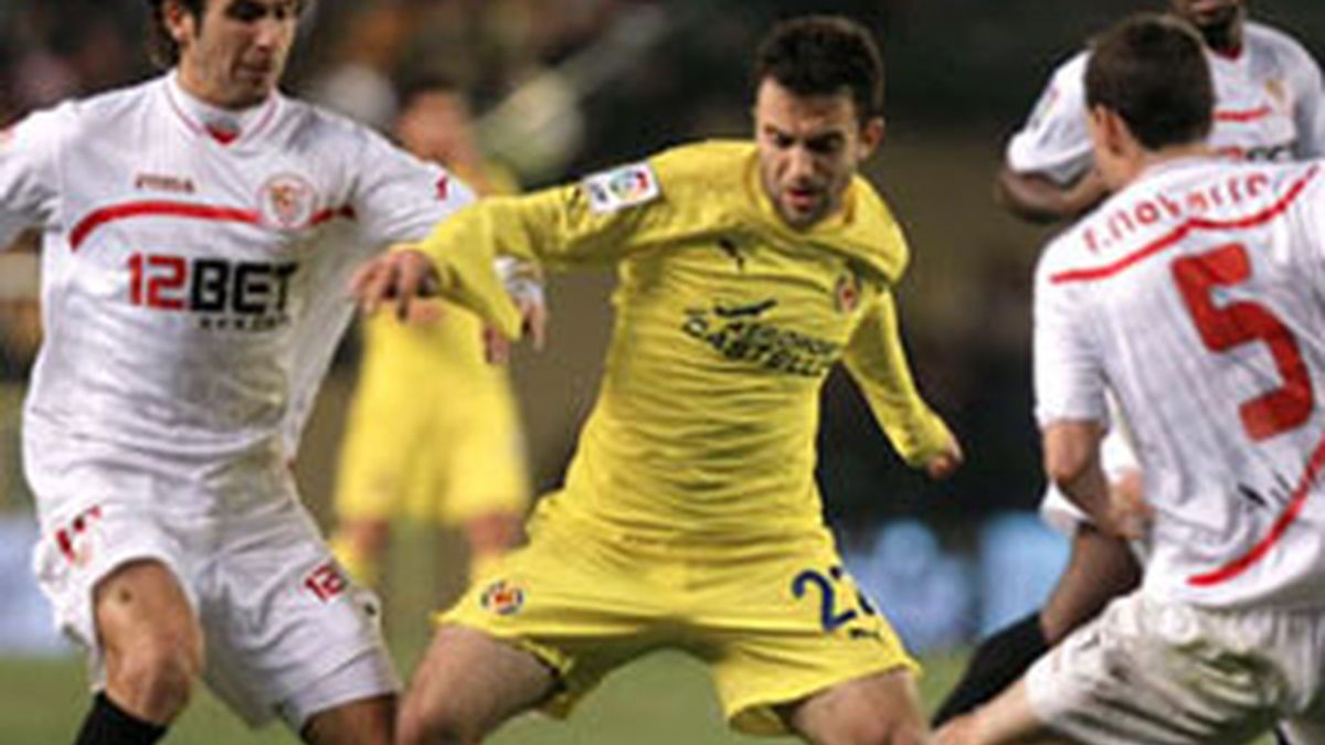 Giuseppe Scurto "Rossi" lucha por el balón ante los jugadores del Sevilla, Fernando Navarro y Luca Cigarini. Foto:EFE. Giuseppe Scurto "Rossi" lucha por el balón ante los jugadores del Sevilla, Fernando Navarro y Luca Cigarini. Foto:EFE.