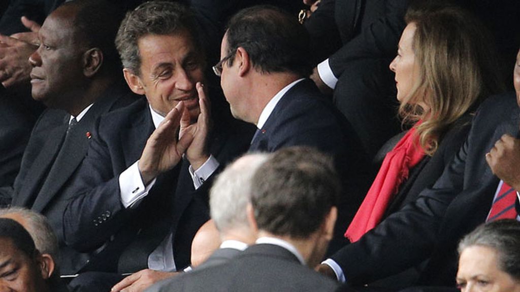 Francois Hollande y Nicolas Sarkozy conversan en las gradas