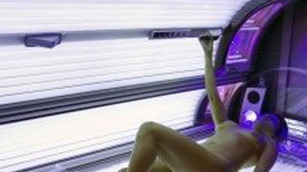 En la imagen una chica bronceándose en una cabina de rayos uva En la imagen una chica bronceándose en una cabina de rayos uva