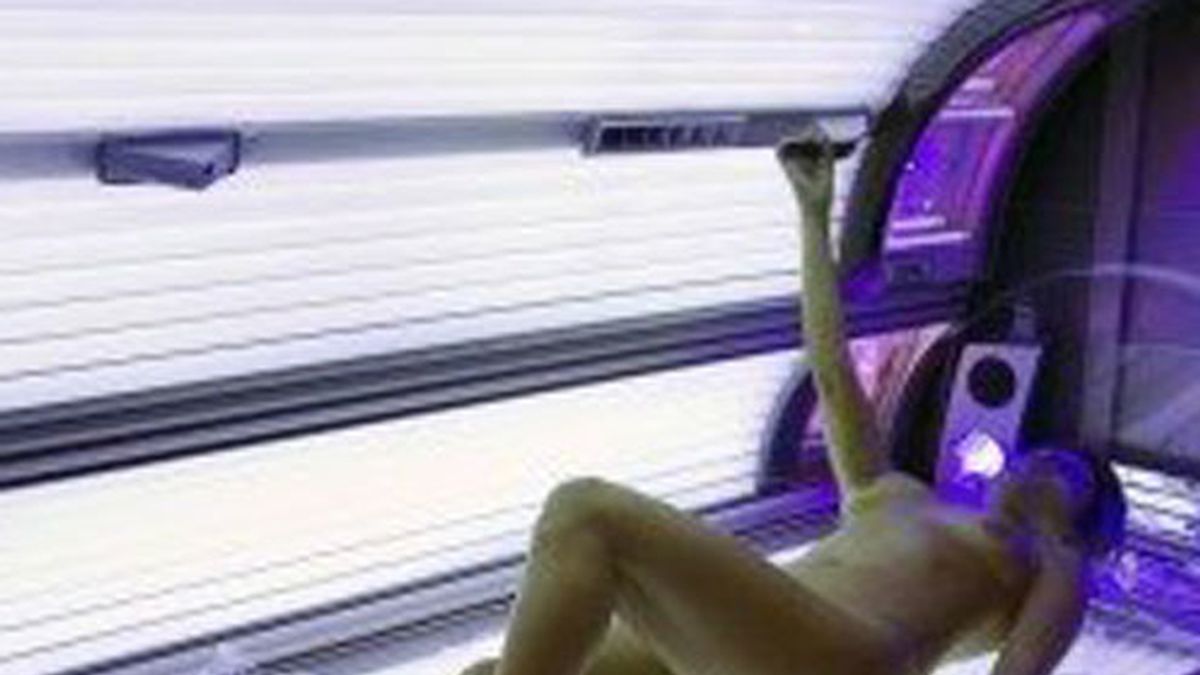 En la imagen una chica bronceándose en una cabina de rayos uva
