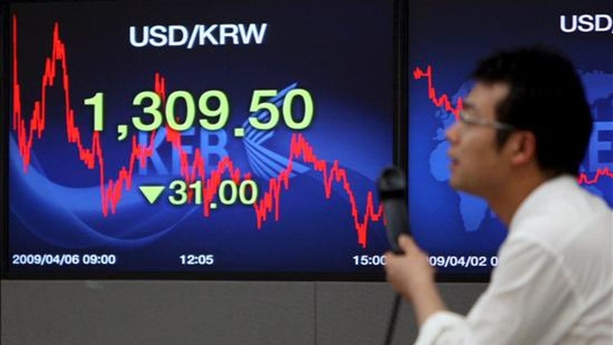 Un hombre pasa por delante de un panel en el que se muestran los valores de la Bolsa en Seúl. EFE/ARCHIVO