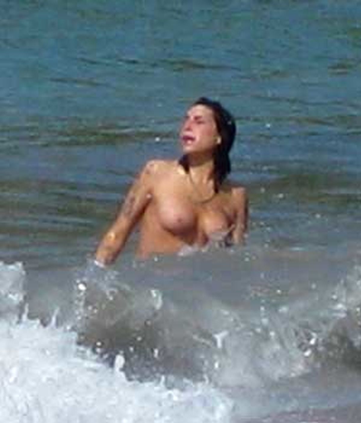 Amy Winehouse, pillada por un paparazzo mientras hace 'topless' en una playa del Caribe. Foto: News of the world.