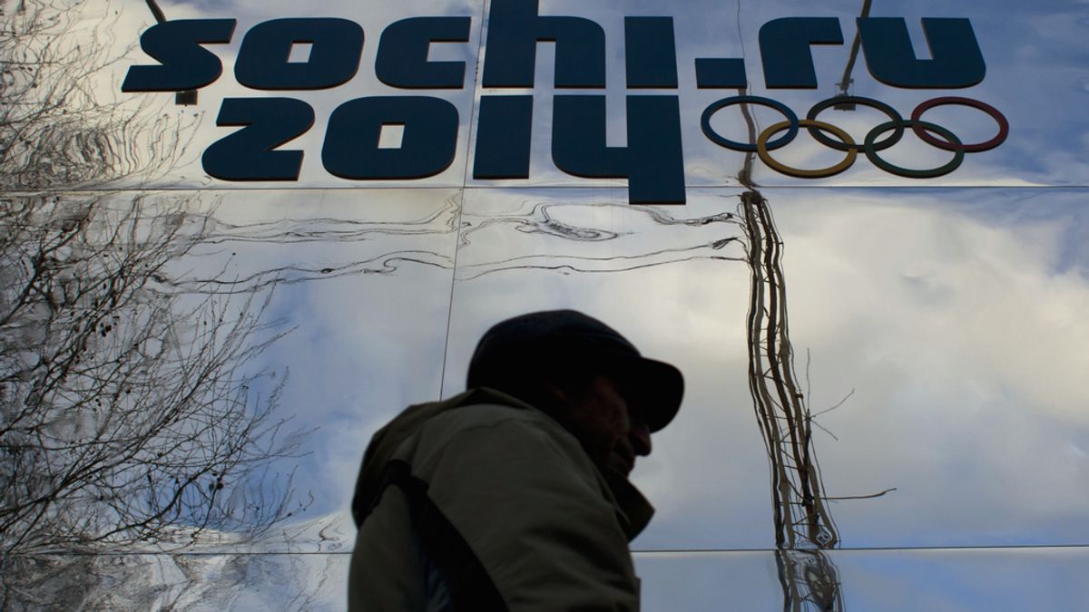 Hombre pasa junto a logotipo olímpico en Sochi (Rusia)