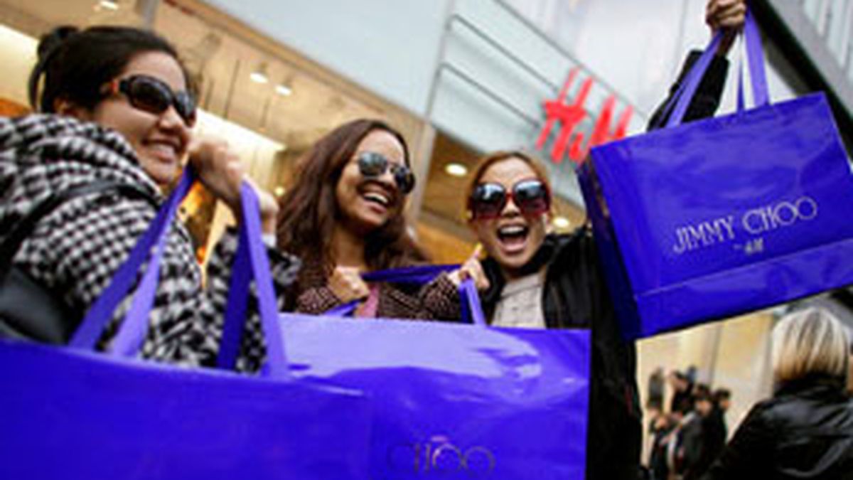 Varias compradoras muestran entusiasmadas sus adquisiciones de Jimmy Choo. Foto: EFE