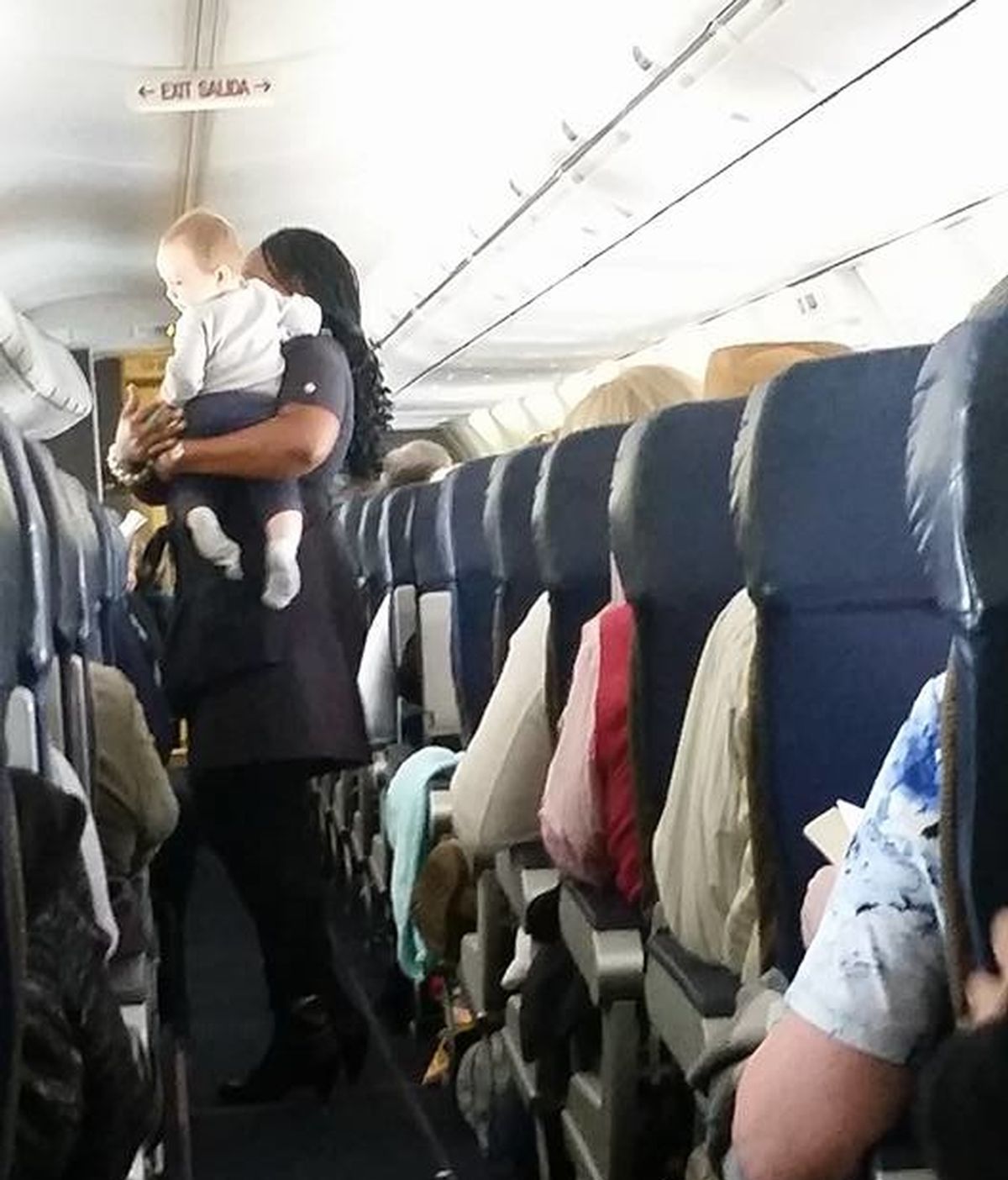 Azafata calma a un niño durante el vuelo