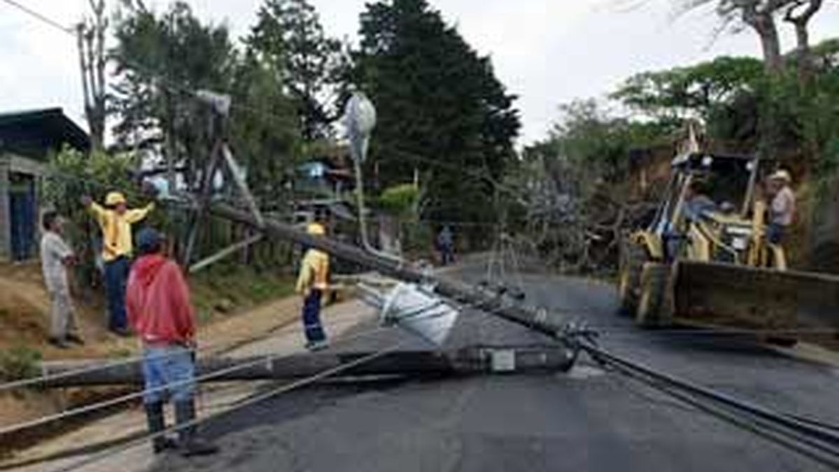Miembros del cuerpo de socorro tratan de abrir paso entre los daños y derrubes en San Isidro de Alajuela, a 50 kilómetros de San José (Costa Rica). Foto: EFE