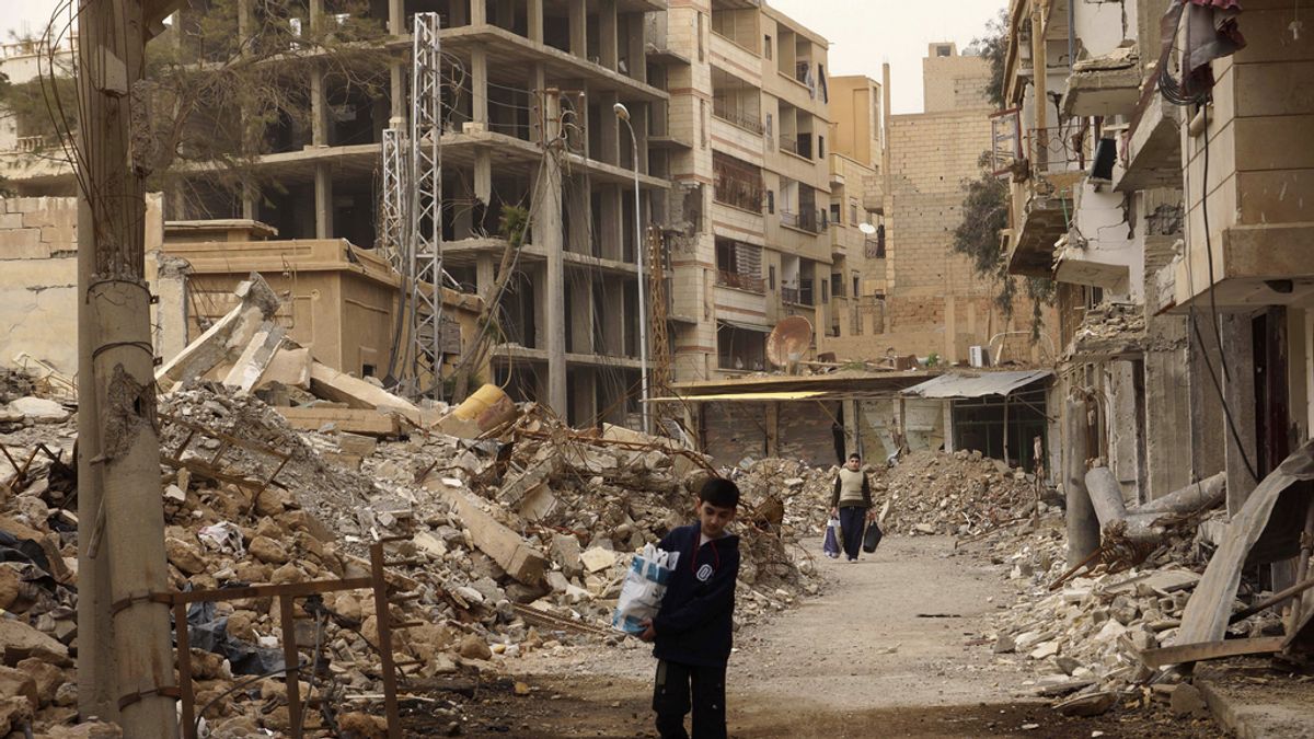 Ciudadanos sirios con sus pertenencias en calles desiertas y destruidas por la guerra