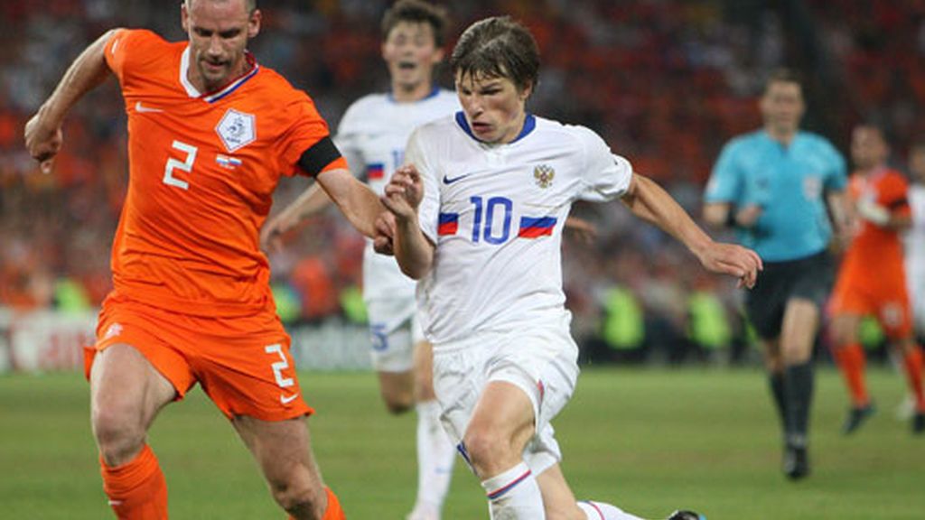 El holandés Andre Ooijer (i) disputa el balón con el ruso Andrei Arshavin (d)