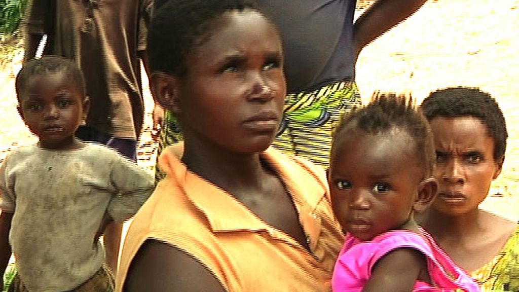 Una mujer porta en brazos a su niña pequeña