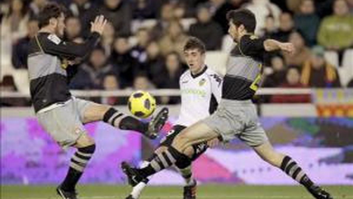 El delantero del Valencia CF, Pablo Hernández (c), trata de centrar entre dos jugadores del RCD Espanyol, durante el partido, correspondiente a la decimoséptima jornada de Liga, que disputaron los dos equipos, en el campo de Mestalla, en Valencia. EFE