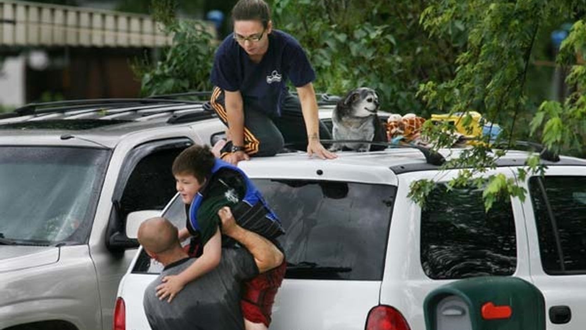 Un chico recoge a un niño atrapado sobre un coche. Foto: AP