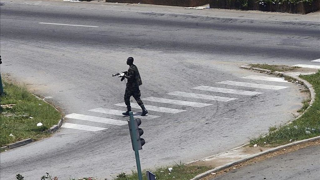 Un soldado leal al presidente Laurent Gbagbo cruza una calle de Abiyán, Costa de Marfil. Oficiales partidarios de Gbagbo instaron hoy, a través de la televisión pública, a la movilización de sus tropas "para proteger las instituciones de la República". EFE