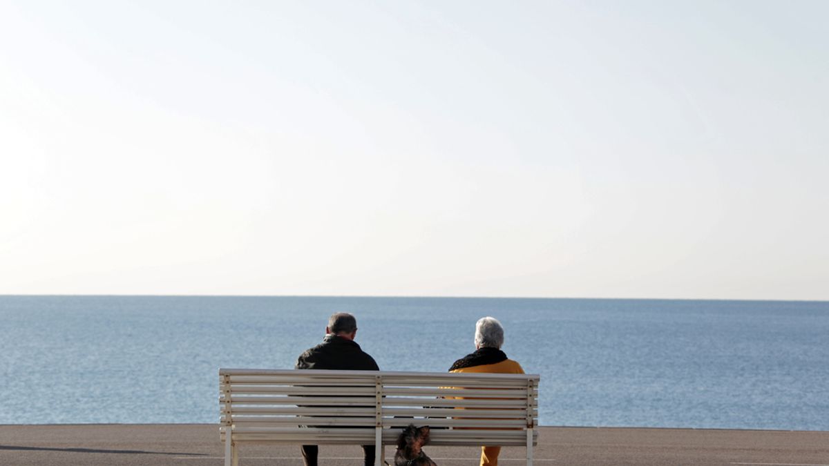 Una pareja sentada ante el mar