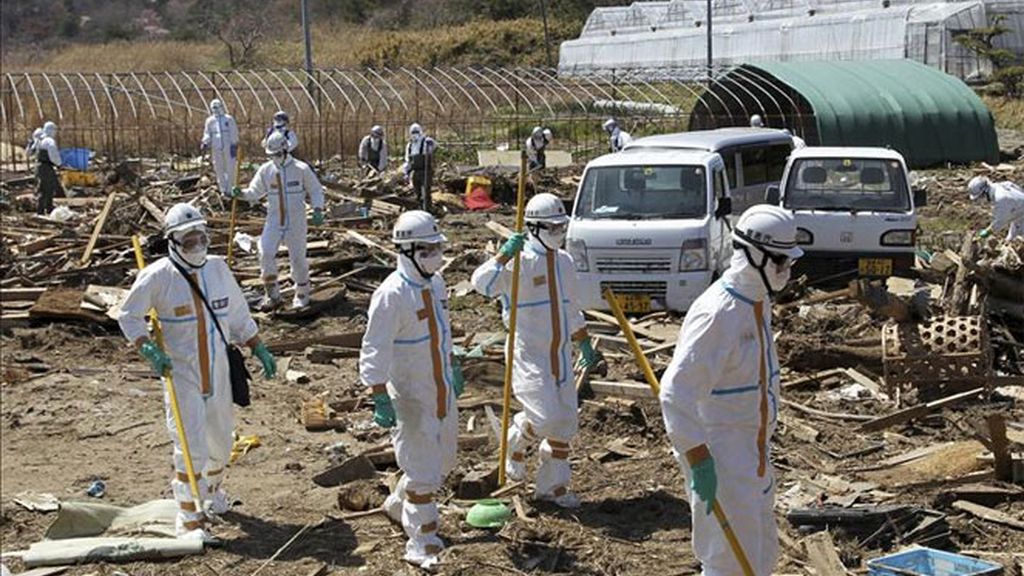 La policía japonesa vestida con trajes de seguridad nuclear buscan víctimas del terremoto y posterior tsunami del 11 de marzo de 2011.