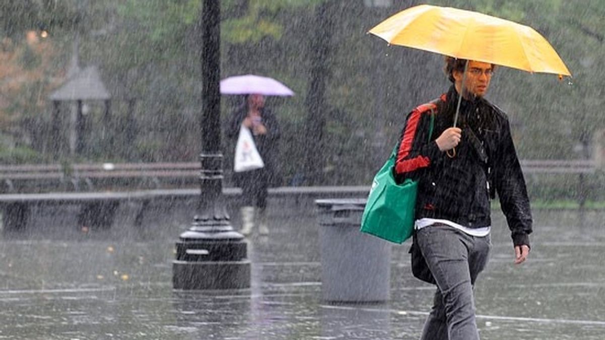 Un hombre se protege de la lluvia Un hombre se protege de la lluvia