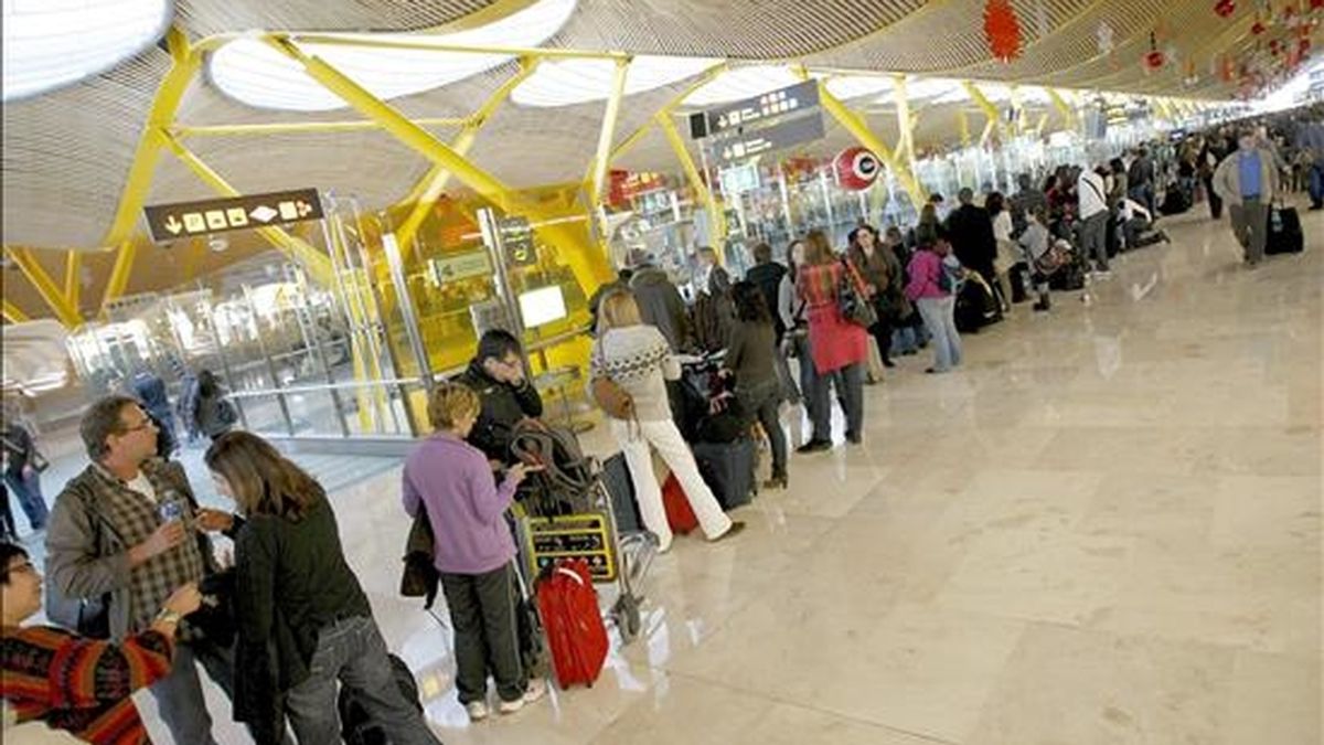 Cientos de personas esperan su turno para ser informados de sus vuelos en el aeropuerto de Madrid Barajas. EFE