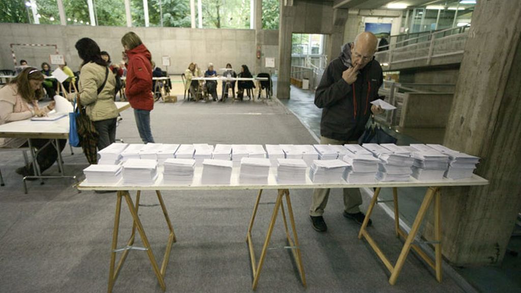 Un votante elige su papeleta en un colegio electoral situado en un centro cívico de Vitoria, en las jornada de las elecciones al Parlamento Vasco