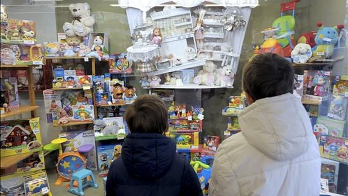 Dos niños miran el escaparate de una juguetería