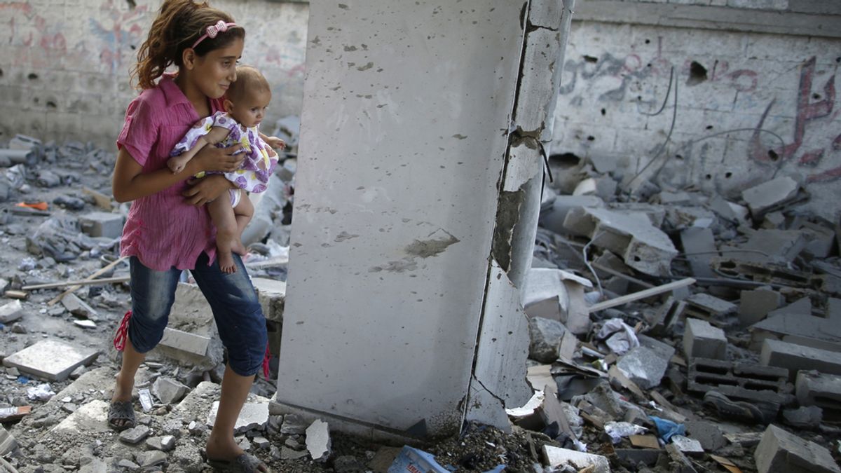 Un niña camino con su hermana por los restos de una mezquita en Gaza