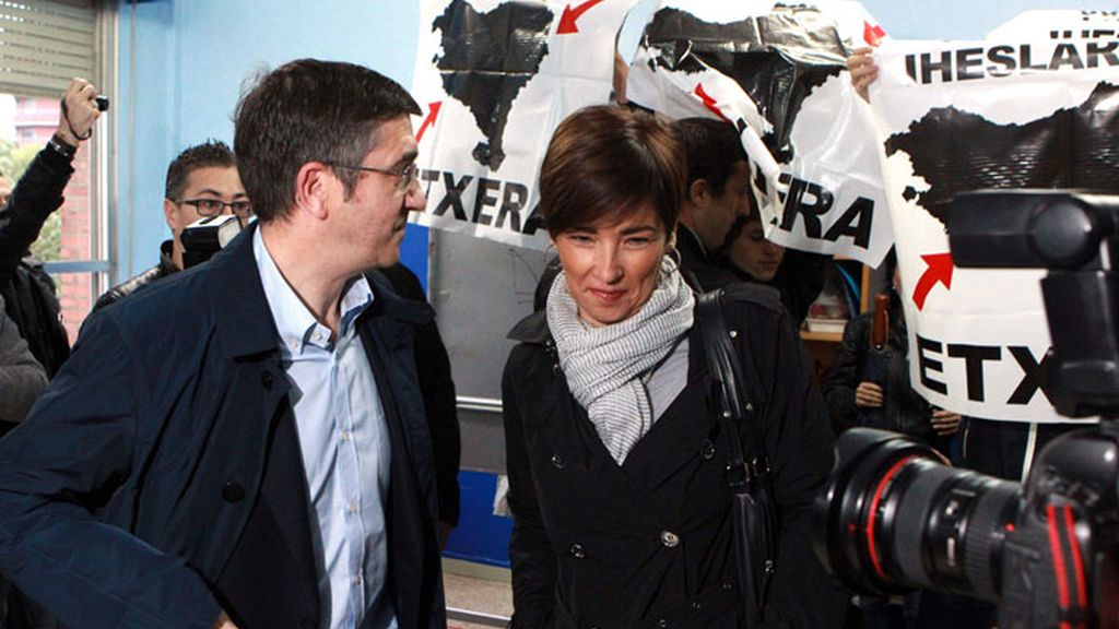 Un grupo de personas ha recibido hoy con carteles en apoyo de los presos de ETA al lehendakari, Patxi López y su esposa, Begoña Gil, en el colegio electoral de Bilbao donde han depositado su voto.