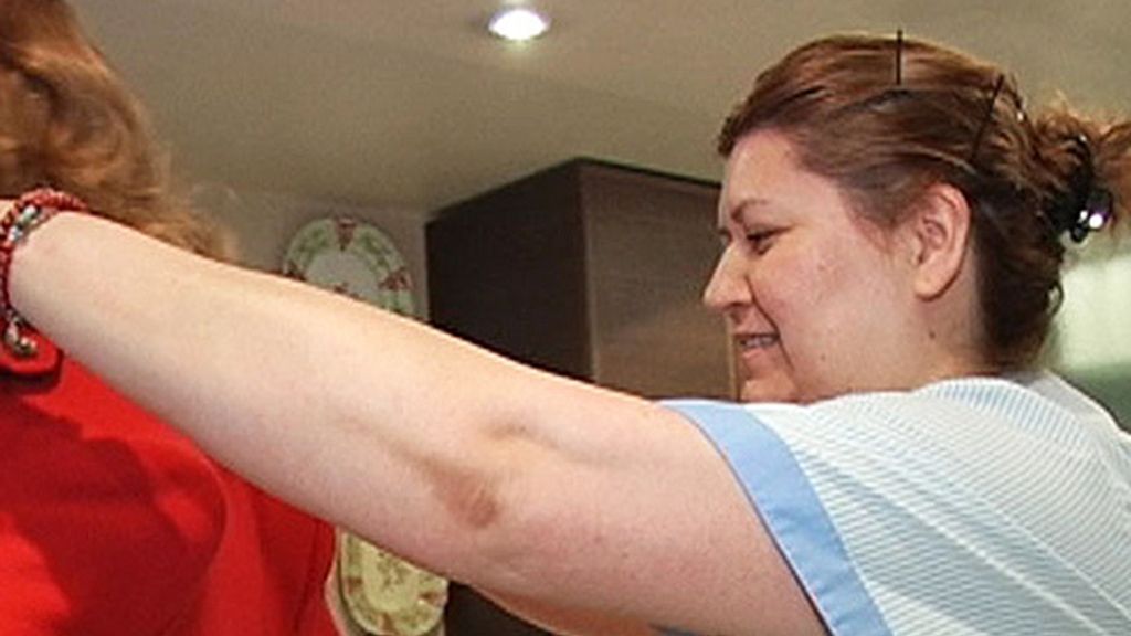 La empleada ayuda a vestir a su jefa