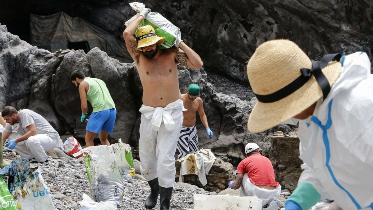 Voluntarios limpian el fuel que ha llegado a la costa